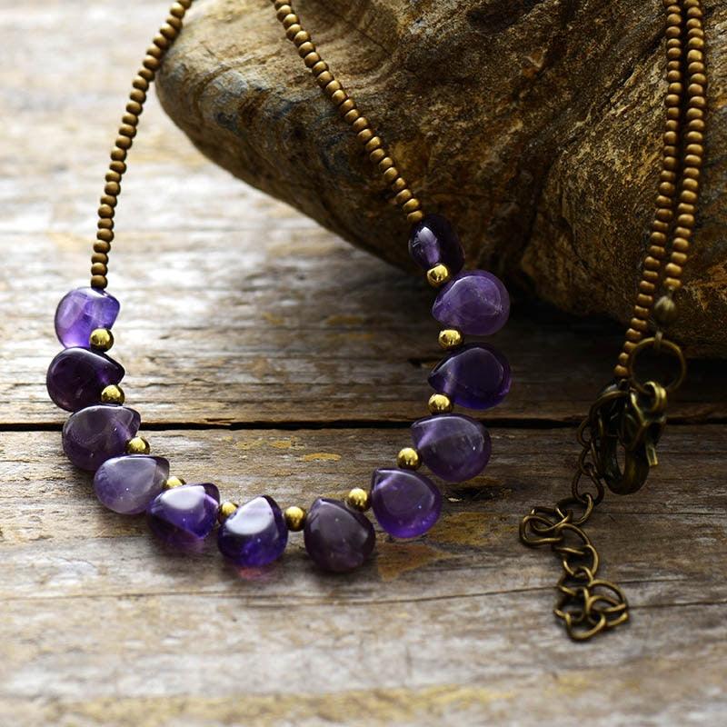 A purple Amethyst and seed bead necklace laid out on a natural background. ALLORA JADE