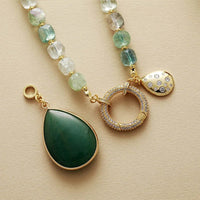 Green Quartz beaded necklace with a green pendant on a beige surface. Green Quartz Pavé Statement Necklace | ALLORA JADE