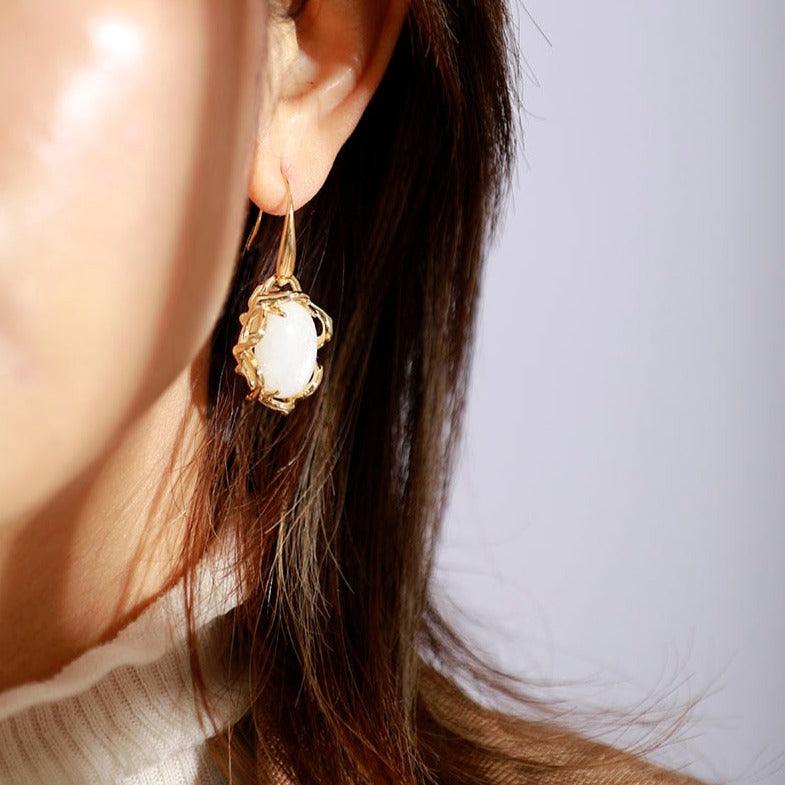 Lady wearing Moonstone Crown Oval Earrings – Handmade moonstone dangle earrings framed in gold, glowing feminine crystal jewellery. - Allora Jade