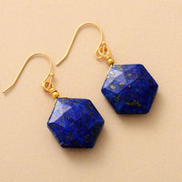 Close-up of Hexagonal Lapis Lazuli gemstone earrings with gold hooks. - ALLORA JADE