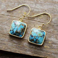 Handmade turquoise square earrings, elegant design, gold finish, displayed on wooden surface. Turquoise Square Drop Earrings | ALLORA JADE