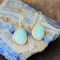 Faceted aqua-green Amazonite crystal earrings on a stone background – calming jewellery from ALLORA JADE