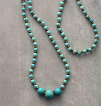 Turquoise beaded bracelet and necklace with gold spacers on grey background - Allora Jade