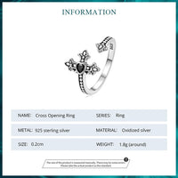 Silver cross opening ring with detailed design on a white background