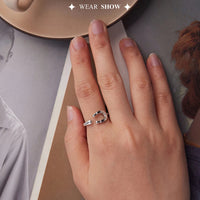 Hand wearing a silver horseshoe ring with a blurred background
