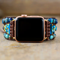 Smartwatch with a decorative band featuring blue and brown beads on a neutral background