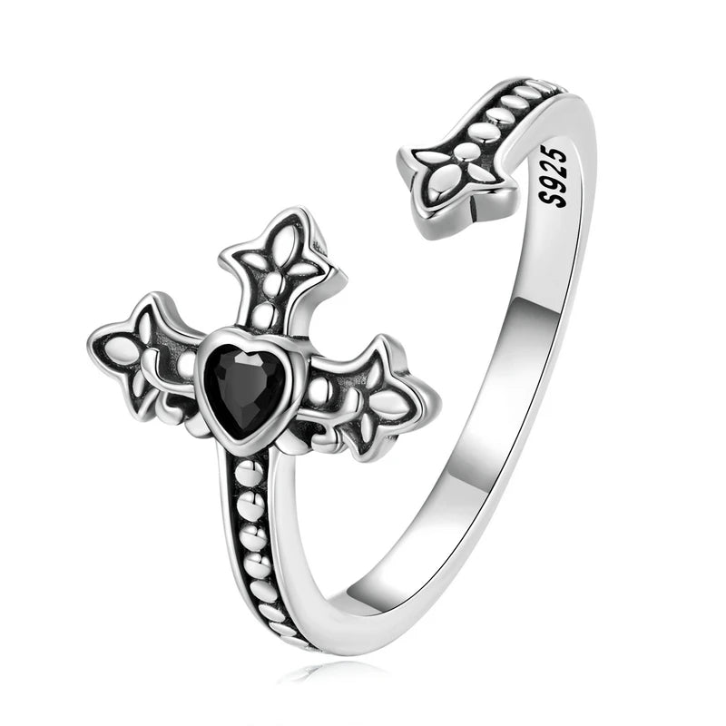 Silver ring with cross design with a black heart cubic zirconia on a white background