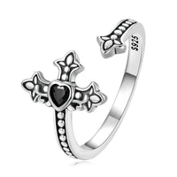 Silver ring with cross design with a black heart cubic zirconia on a white background