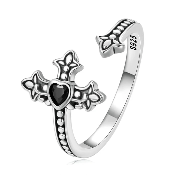 Silver ring with cross design with a black heart cubic zirconia on a white background