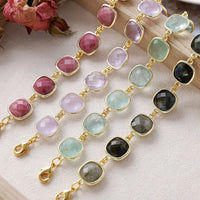 Bracelets with multicoloured gemstones on a textured surface