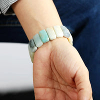 Close-up of a hand wearing a bracelet with gradient stones. Amazonite Stretchy Apple Watch Band | ALLORA JADE