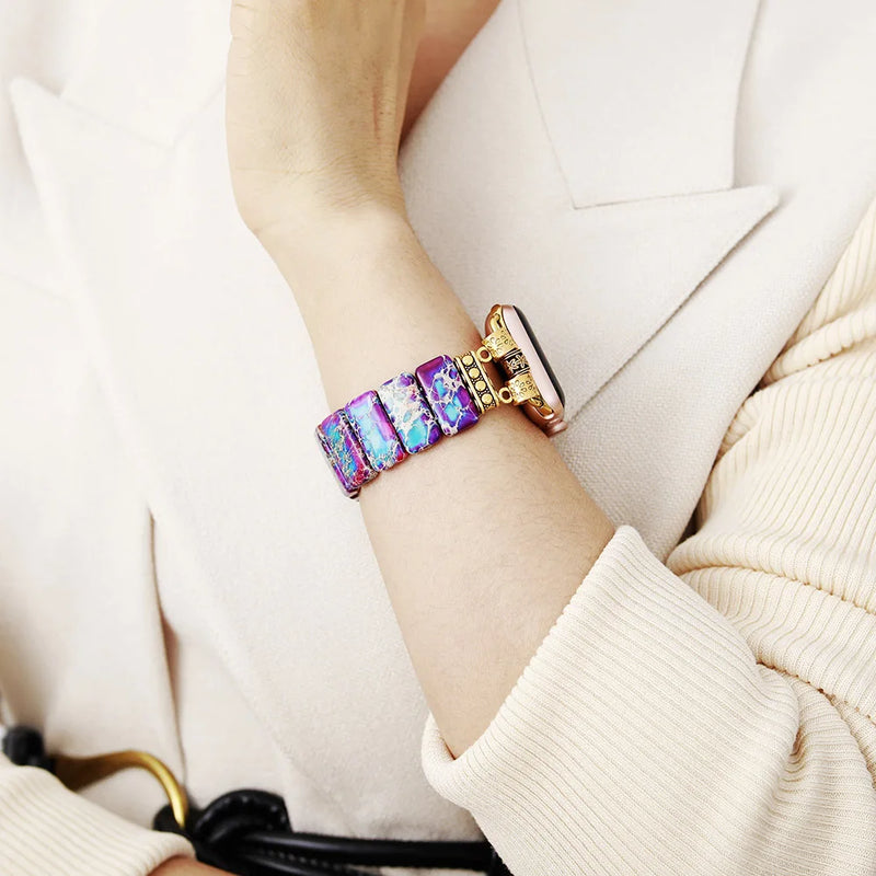 Multicolored bracelet on a person's wrist with a neutral background. Purple Aqua Jasper Stretchy Apple Watch Band - gold | ALLORA JADE