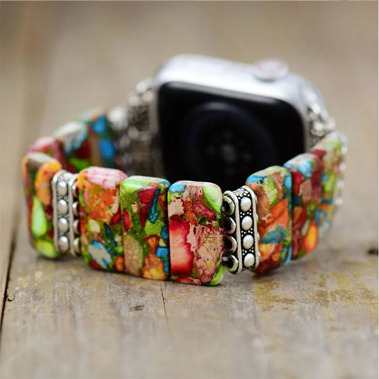 Colourful beaded watch band on a smartwatch with a rustic wooden background. Flower Jasper Stretchy Apple Watch Band | ALLORA JADE