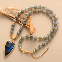 Beaded necklace with a heart-shaped pendant on a beige background