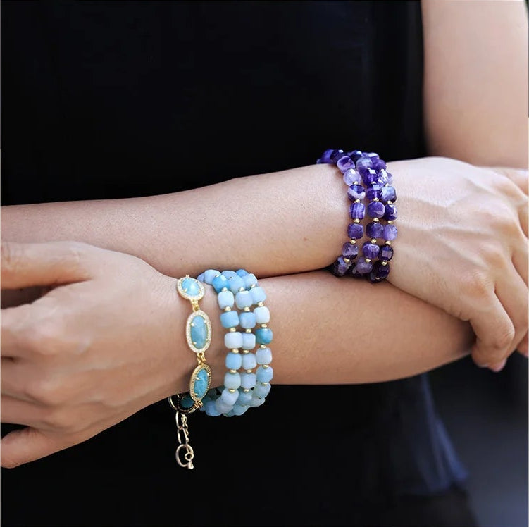 Model wearing purple and blue beaded bracelets. 