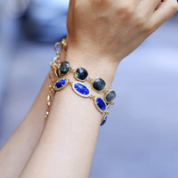 Bracelet with blue stones on a wrist against a blurred background