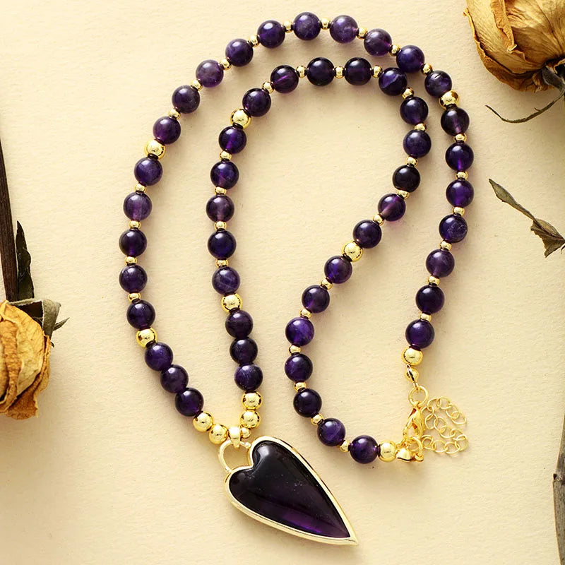 Amethyst beaded necklace with an Amethyst heart-shaped pendant on a beige background.