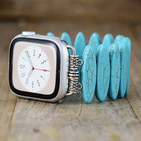 Smartwatch with a turquoise bracelet on a wooden surface. Turquoise Beads Stretchy Apple Watch Band | ALLORA JADE