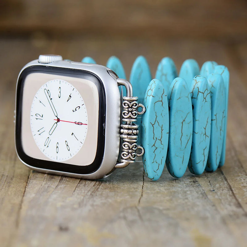 Smartwatch with a turquoise bracelet on a wooden surface. Turquoise Beads Stretchy Apple Watch Band | ALLORA JADE