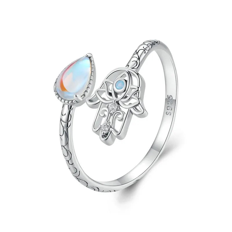 Silver ring with a teardrop-shaped gemstone and Hamsa hand design on a white background